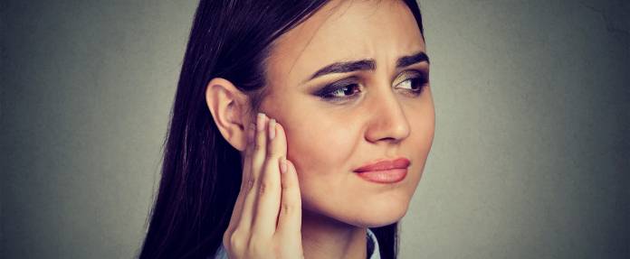 Junge Frau mit Ohrgeräusch, Tinnitus