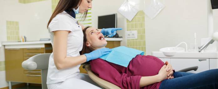 Schwangere Frau bei Zahnarzt-Behandlung
