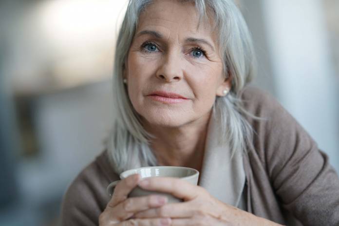 Ältere Frau mit Tasse in der Hand