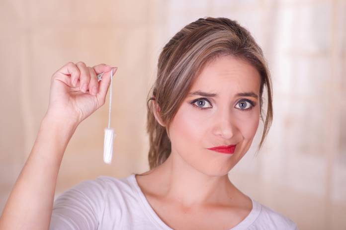 Frau mit Tampon in der Hand